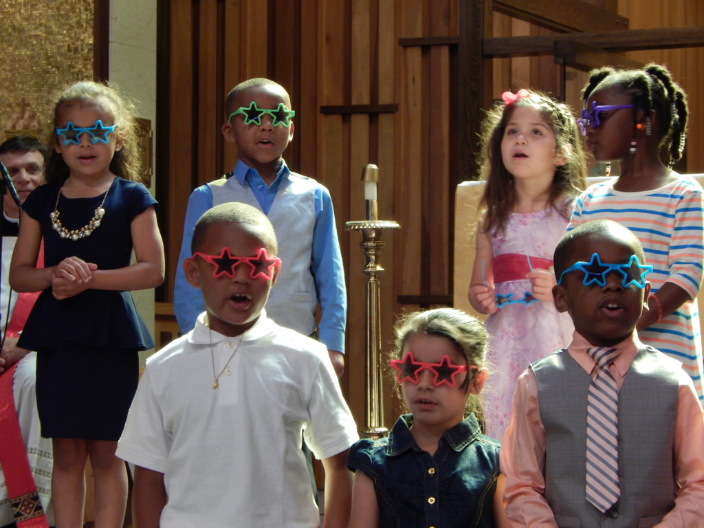 Catholic children at St Joseph the Provider School wearing colorful star-shaped sunglasses